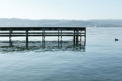 Pier on sea against clear sky