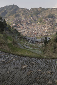 High angle view of agricultural field by buildings