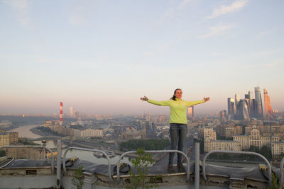 Woman standing on building in city