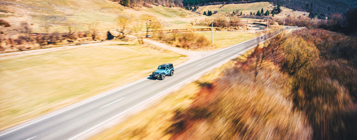 Blurred motion of person riding motorcycle on road