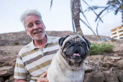 Senior man holding pug