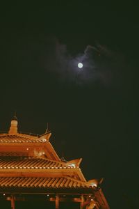 Low angle view of illuminated building against sky at night