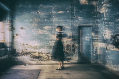 Blurred motion of woman standing in abandoned house