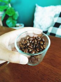 Hand holding coffee cup on table