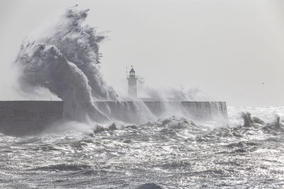 Water splashing in sea against clear sky