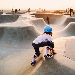 Full length of boy skateboarding on skateboard against sky