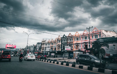 Cars on road in city against sky