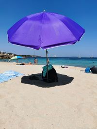 Deck chairs on beach against sky