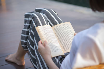 Midsection of person holding book