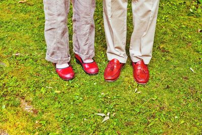 Man and woman in red shoes on grass