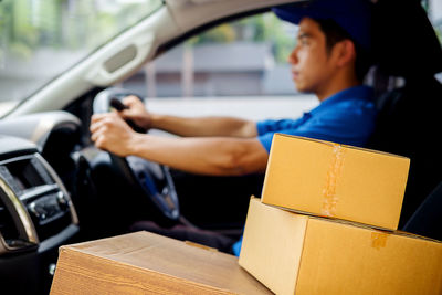 Delivery person with boxes while traveling in car