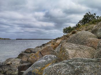 Rocks by sea against sky