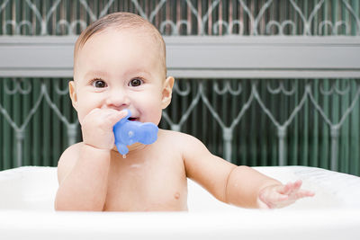 Portrait of baby boy with toy in bathtub