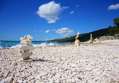 Stones on beach against sky