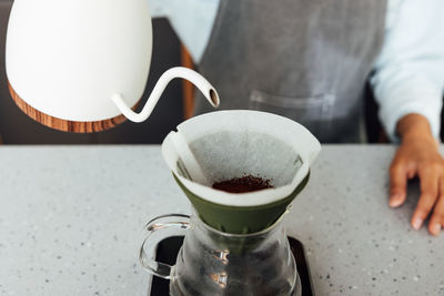 Midsection of man holding coffee on table