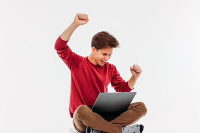 Young man using mobile phone against white background