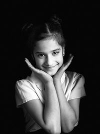Portrait of smiling girl over black background