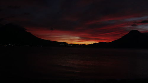 Scenic view of silhouette mountains against orange sky