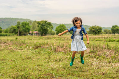 Portrait of smiling girl standing on field