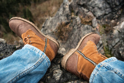 Low section of man wearing shoes on rock