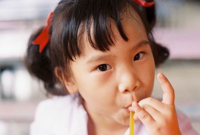 Close-up portrait of girl having drink through straw