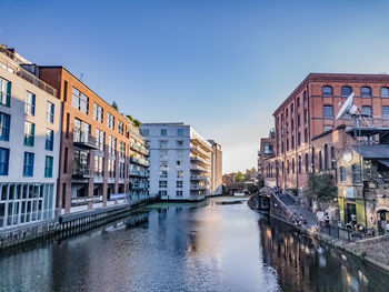 Canal amidst buildings against sky in city