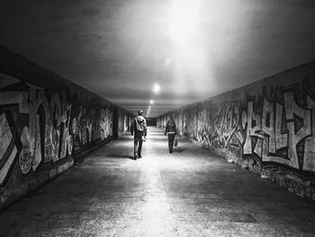 People walking on illuminated bridge