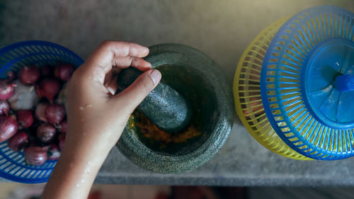 A mortar and pestle or lesung batu in malay with onion and chillies / spices. cooking concept.