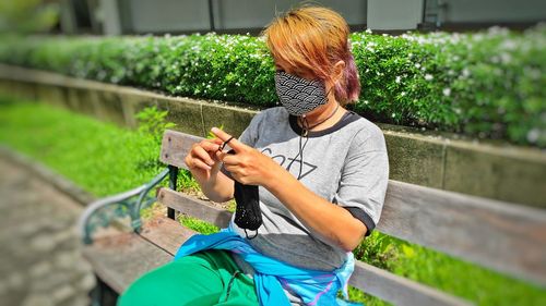 Full length of woman holding mobile phone outdoors