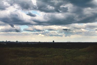 Scenic view of grassy field against cloudy sky