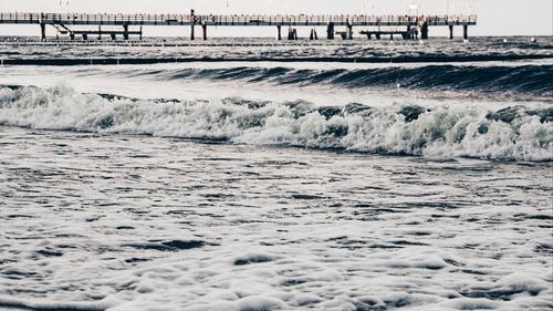 Surface level of pier on beach against sky