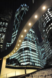 Low angle view of illuminated buildings against sky at night