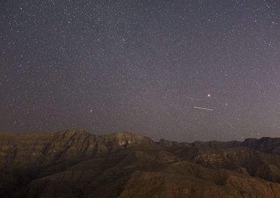 Scenic view of mountains against sky at night