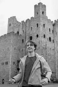 Low angle view of smiling man against historic building