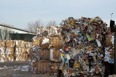 Stack of garbage on metal structure against sky