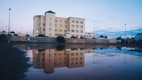 Reflection of building in puddle on lake