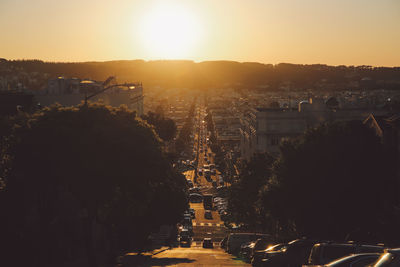 Illuminated cityscape against sky during sunset