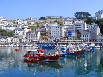 Ships moored at harbor by residential district