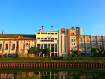 Buildings in front of residential district against clear blue sky