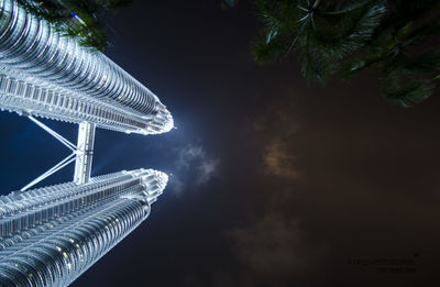 Low angle view of twin tower against sky at night at kuala lumpur,  malaysia