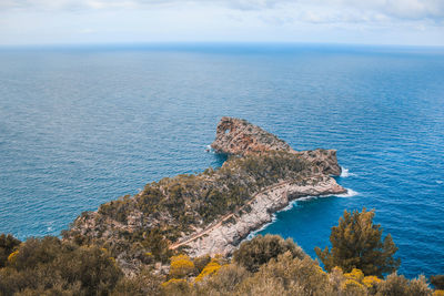 High angle view of rocks by sea against sky