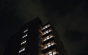 LOW ANGLE VIEW OF ILLUMINATED BUILDING AGAINST SKY