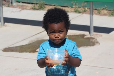 Portrait of cute boy holding outdoors