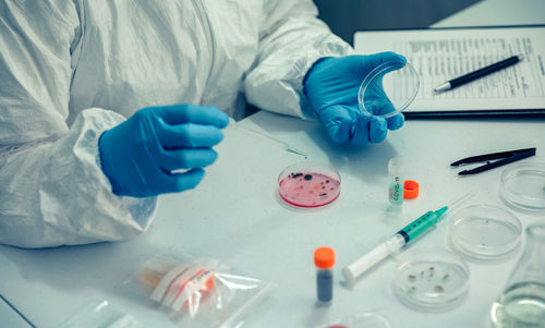 Midsection of scientist doing experiment on desk