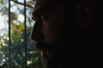 Profile of man looking out the window at nature