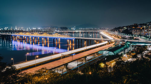 High angle view of illuminated bridge over river in city