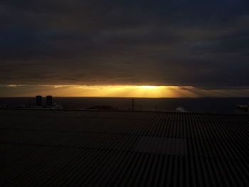 Scenic view of beach against sky at sunset