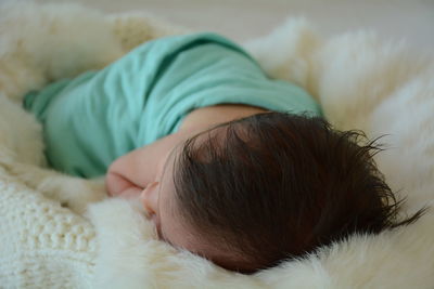 Close-up of baby sleeping on bed at home