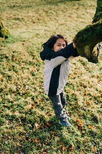 Boy playing by tree in field during winter