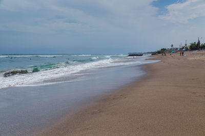 Scenic view of beach against cloudy sky
